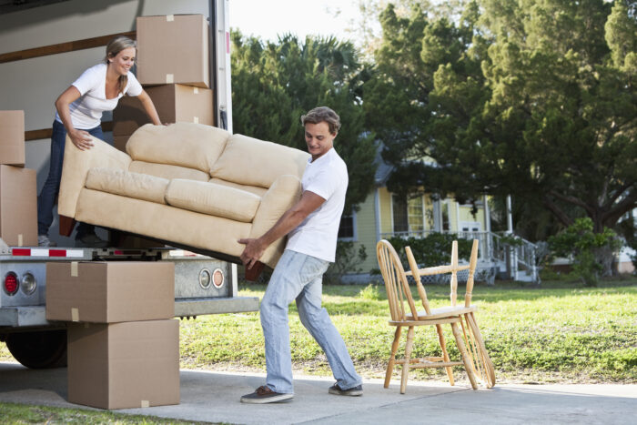 Couple lifting couch out of a moving van