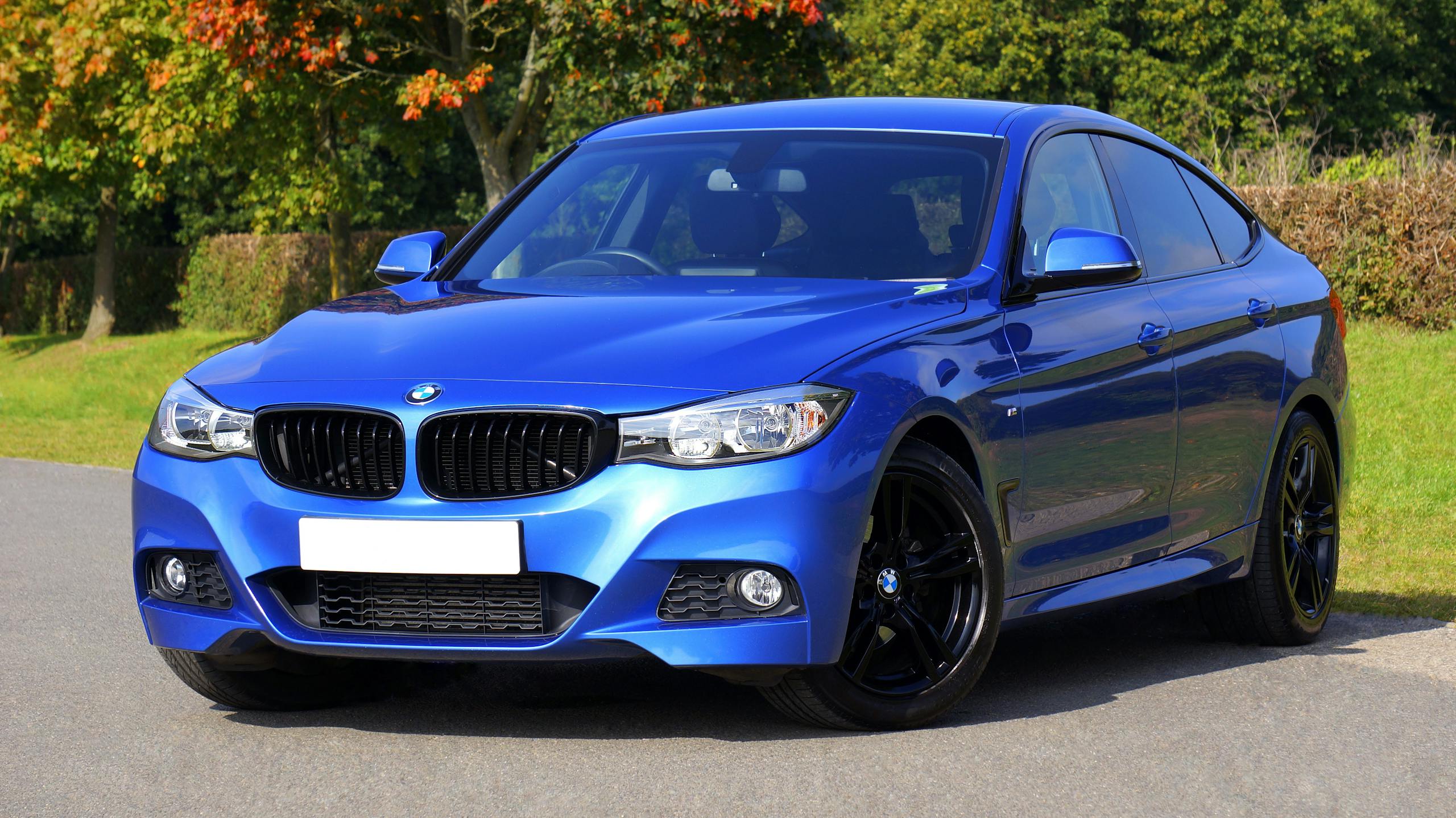 Modern blue luxury car parked by a scenic roadside on a sunny day. Stylish design.